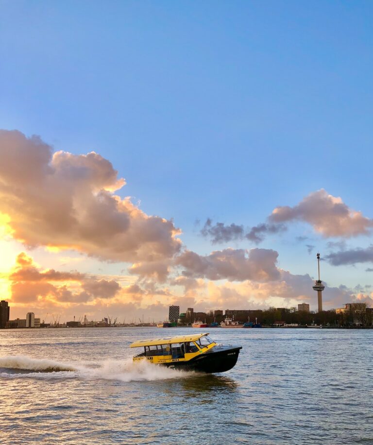 a yellow and black boat traveling across a body of water